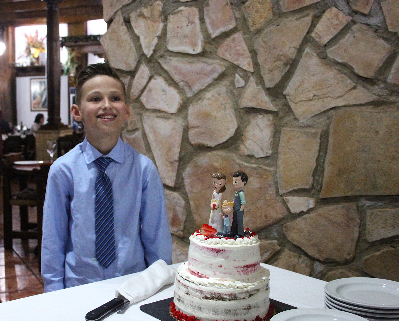 Il bambino, felice accanto alla torta nuziale