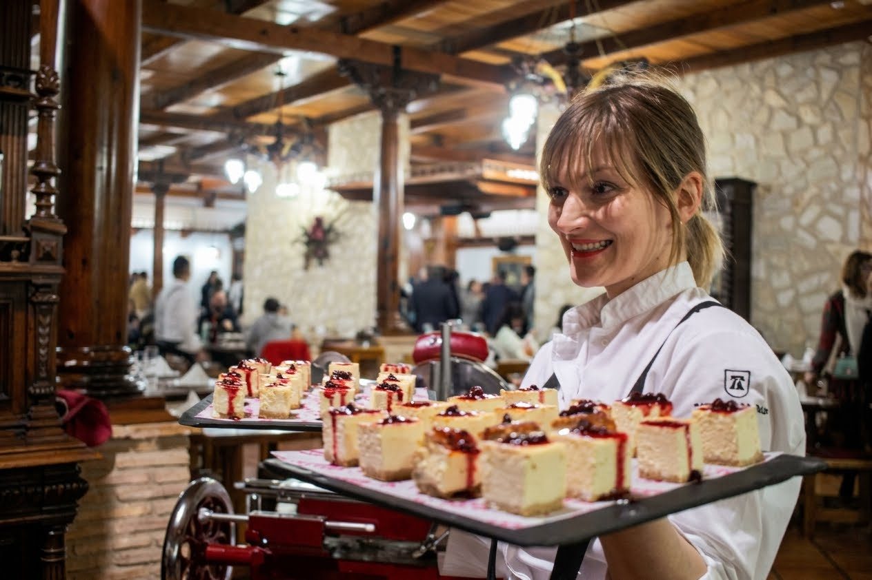 Cameriera con un vassoio di cheesecake in sala