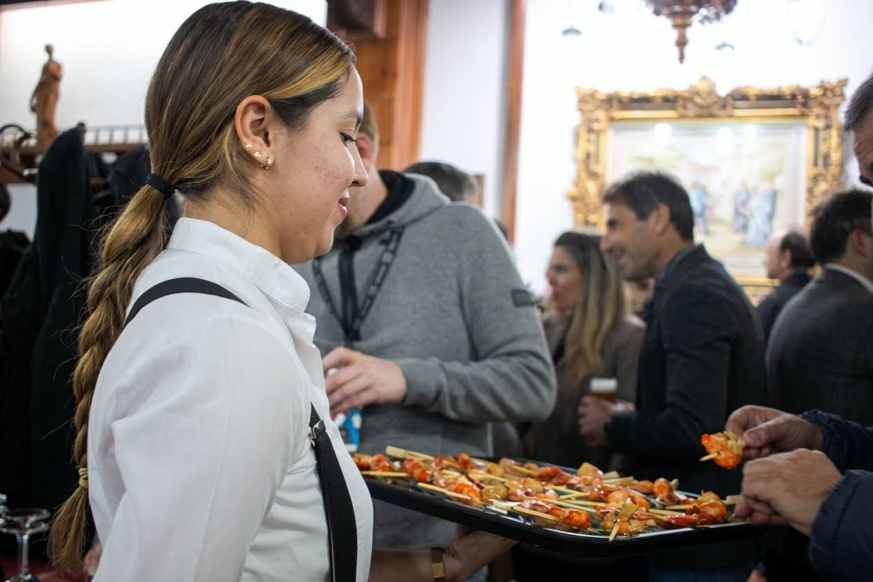 Cameriera con un vassoio di tapas tra gli invitati